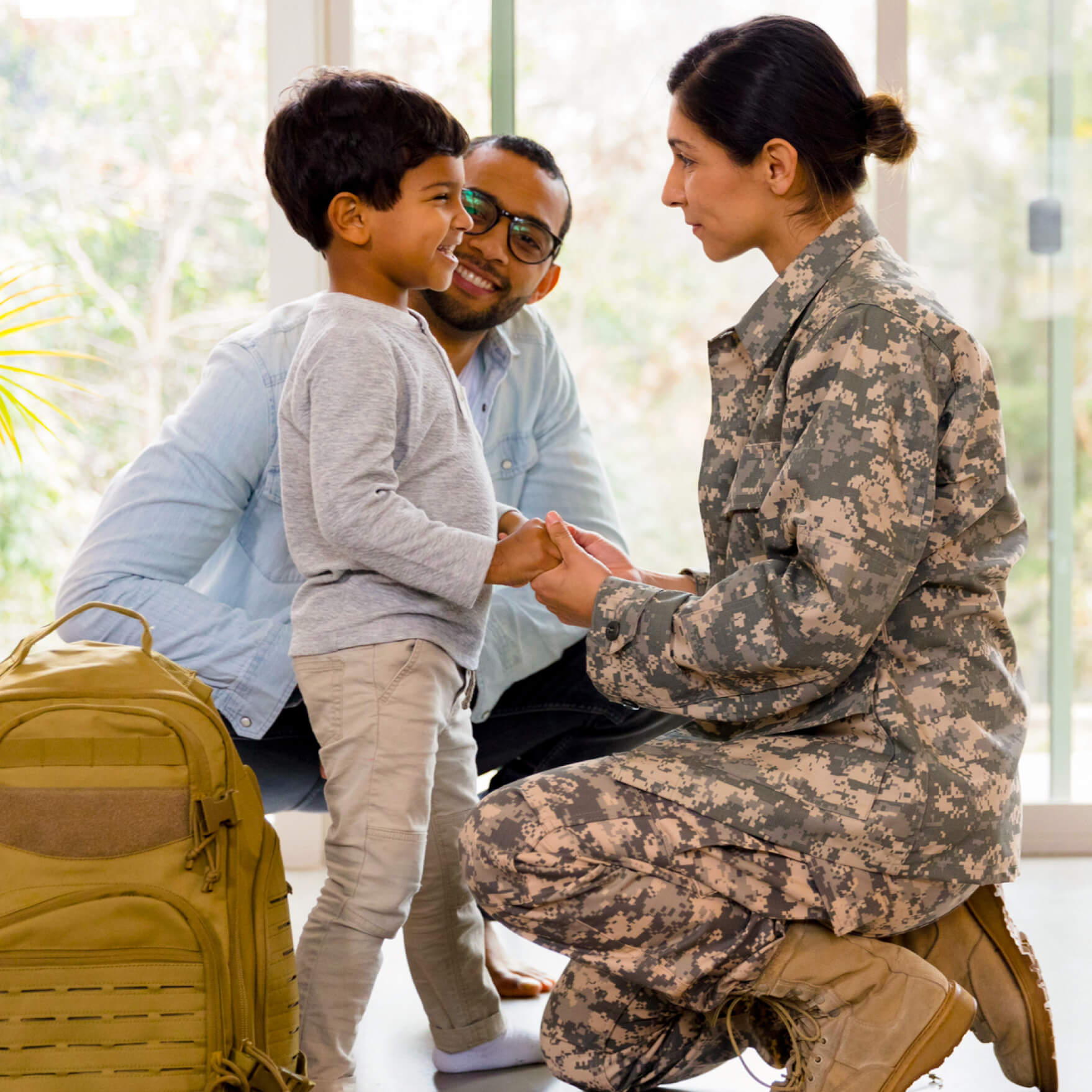 Capital One military mom kneels in uniform with her young son